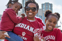 Parent with two children wearing Indiana University gear.